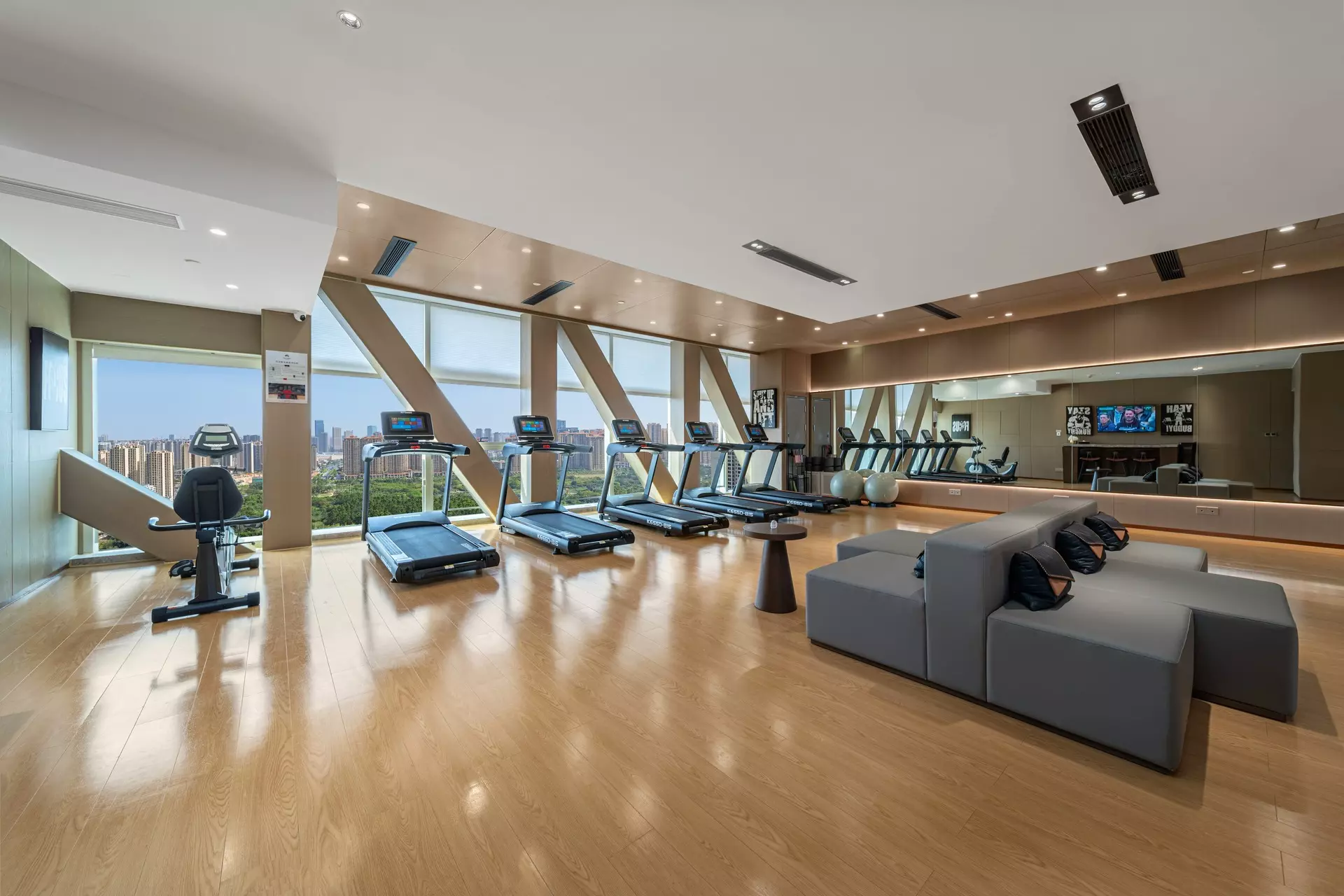 Modern hotel fitness center with custom wood accents and ceiling tracks